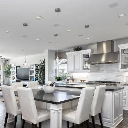 Kitchen and living area with in-ceiling speakers and a television