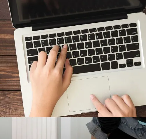 Hands typing on a laptop keyboard