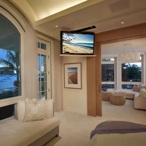 Television lowered from a ceiling lift in a bedroom