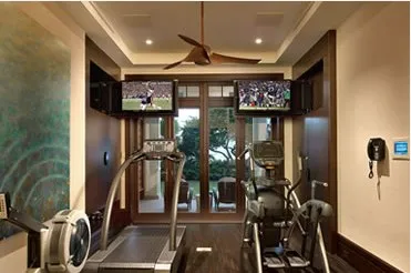 Home gym with two televisions and exercise equipment