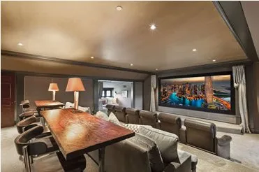 Media room with a large screen, a long table, and lounge seating