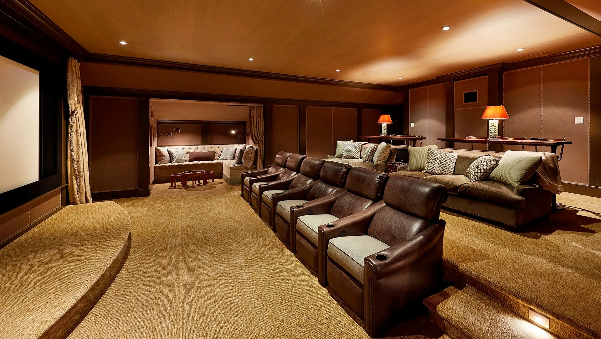 Home theater with a row of leather recliners, a lounge sofa, and a projection screen